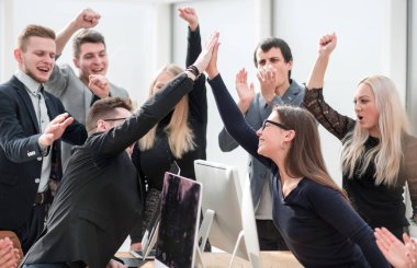 Başarılarını gösteren bir jestle mutlu bir iş ekibi.