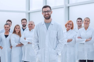 Gülümseyen araştırma danışmanı ekibinin önünde duruyor..