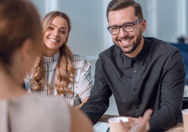 İş ekibi bir fincan kahve eşliğinde iş konularını tartışıyor.