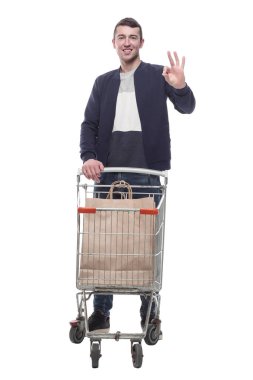 Alışveriş arabasıyla gülümseyen genç adam. bir beyaz üzerinde izole