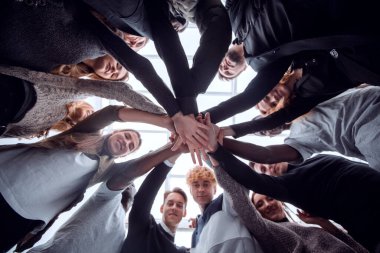 Alt manzara. Bir grup mutlu genç insan ellerinden bir kule yapıyorlar. .