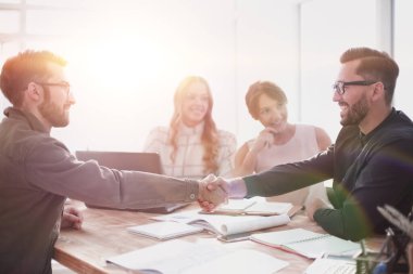 Ofisteki bir toplantıda tokalaşan iş adamları.