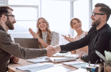 Ofisteki bir toplantıda tokalaşan iş adamları.