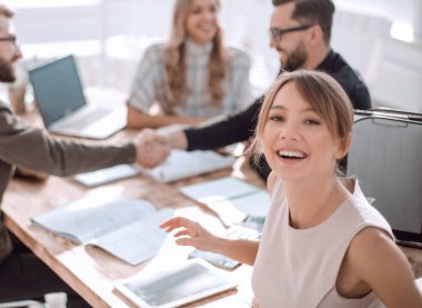 İş adamları ofis masasında el sıkışıyor..