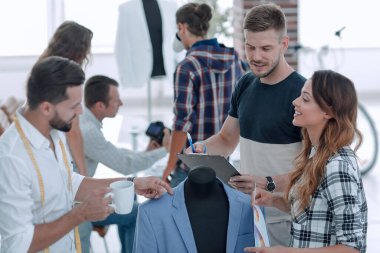 Bir grup tasarımcı erkek kıyafetlerini tartışıyor