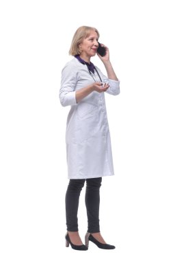 Tıbbi önlüklü kadın doktorun cep telefonuyla konuşması.