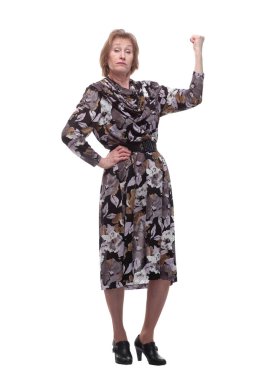 Kolunu kaldırıp kameraya bakan yaşlı bir kadın beyaz arka planda tek başına duruyor.