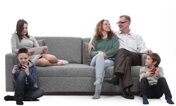 Família feliz sentado em um grande sofá confortável. — Fotografia de Stock