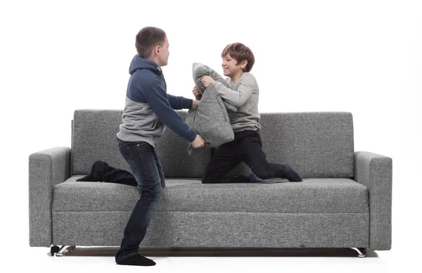Two brothers have a pillow fight on the couch. — Stock Photo, Image