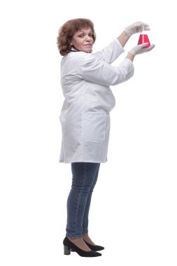 Yan görünüş. Doktor bir şişe kırmızı sıvıya bakıyor.