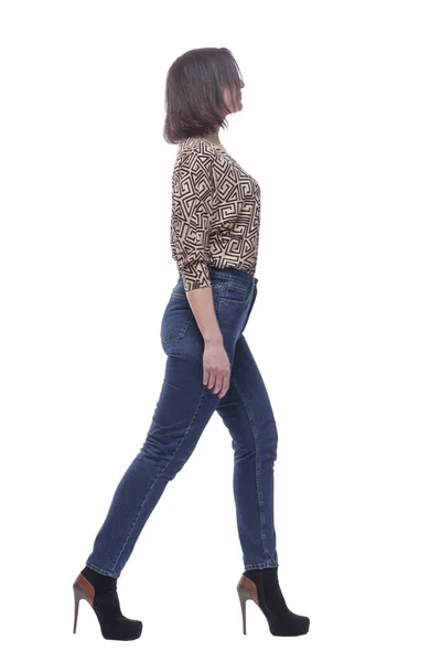 Attractive young woman in jeans striding forward. — Stock Photo, Image