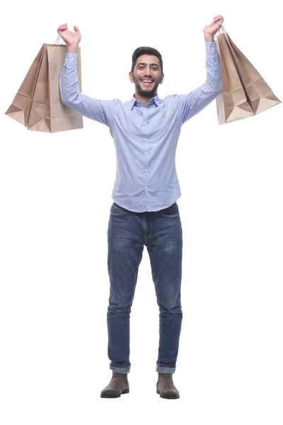 Glücklicher junger Mann zeigt seine vollen Einkaufstüten. — Stockfoto