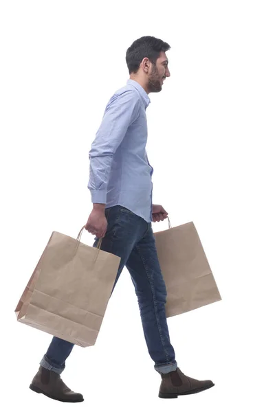 Ελκυστικός άνθρωπος με τσάντες ψώνια με τα πόδια στο σπίτι. — Φωτογραφία Αρχείου