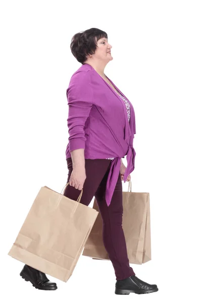 Lässige ältere Frau mit Einkaufstüten schreitet vorwärts. — Stockfoto