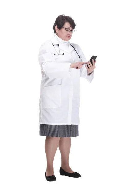 In full growth. senior female medic with a smartphone. — Stock Photo, Image