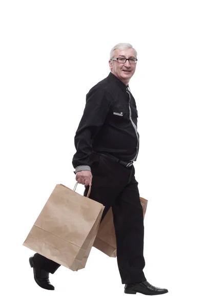 Lässiger Mann mit Einkaufstüten schreitet voran. — Stockfoto