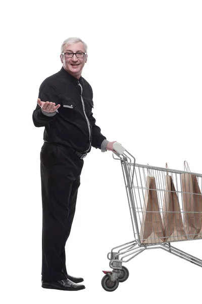 In full growth. happy old man with a shopping cart . — Stock Photo, Image