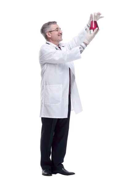 Uśmiechnięty lekarz patrzący na płyn w kolbie — Zdjęcie stockowe