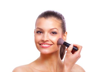 Kozmetik boya fırçası kullanan güzel bir genç kadın.