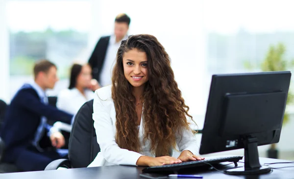 Glad ung affärskvinna ser bakom och hennes kollegor arbetar — Stockfoto
