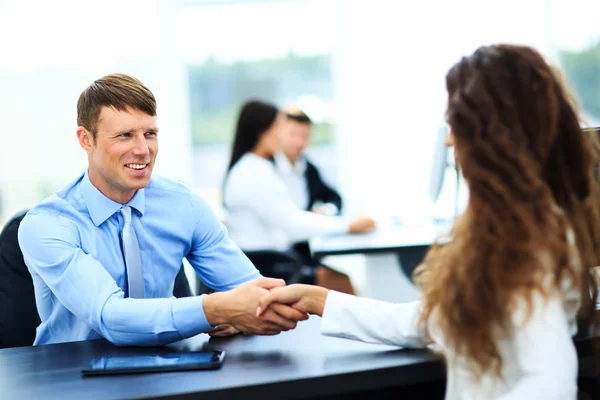 Salesman shaking hands to clients — Stock Photo, Image