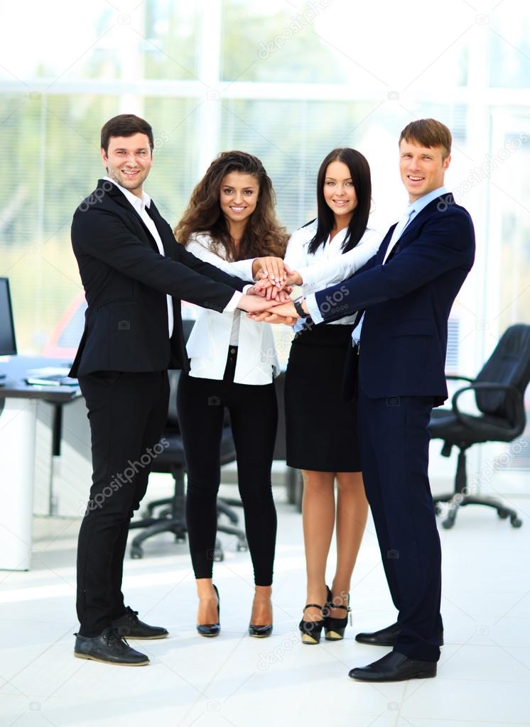 Group of business people piling up their hands together in the w