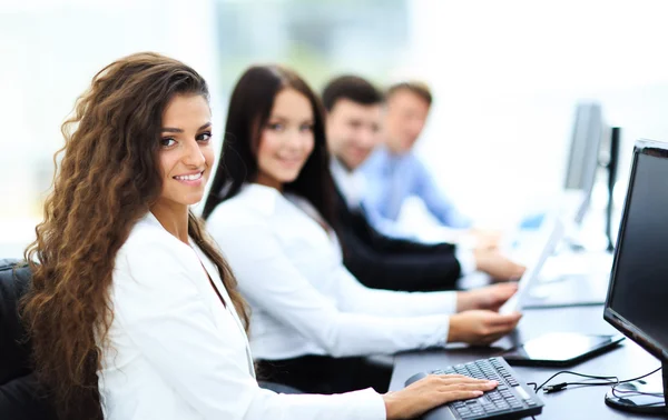 Glad ung affärskvinna ser bakom och hennes kollegor arbetar — Stockfoto