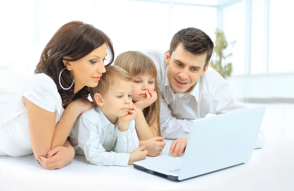 Família olhando para o laptop entusiasticamente — Fotografia de Stock