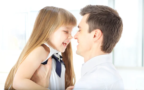 Felice padre che tiene la figlia sulle mani ridendo rivolto al suo volto — Foto Stock