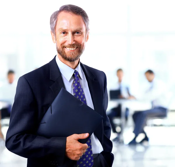 Erwachsener Mann lächelt in die Kamera und hält einen Ordner in der Hand — Stockfoto