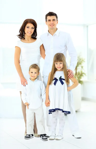 Happy family consisting of mom dad doughterl and son looks at the camera and smiling — Stock Photo, Image
