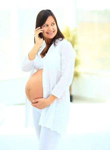 Zwangere vrouw praten over de mobiele telefoon — Stockfoto