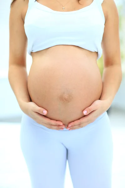 Kvinnan håller sin baby bump — Stockfoto
