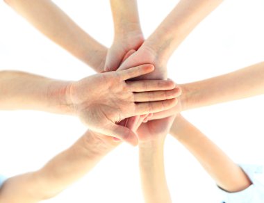 Close-up Of Businesspeople Hands Stacking Together Over White Background