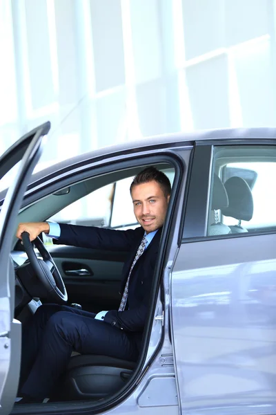 Young man choosing car at salon — Stock Photo, Image