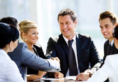 İki işadamı büyük bir anlaşma yaptıktan sonra el sıkışıyor.