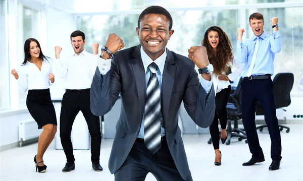 Equipo de negocios celebrando un triunfo con los brazos en alto — Foto de Stock