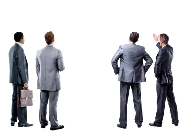 Quatro homens de negócios na parte de trás olhando para algo sobre um fundo branco — Fotografia de Stock