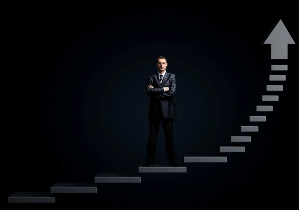 Бизнесмен, стоящий на лестнице — стоковое фото