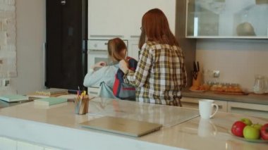 Sevimli küçük kız okulu bırakmak için evden ayrılıyor, annesine sarılıp veda ediyor.