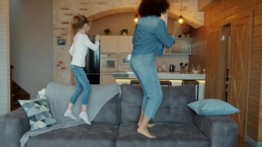 Bebek bakıcısının ağır çekimde dans etmesi ve kanepede zıplaması evde müzik dinlemenin keyfini çıkarması.