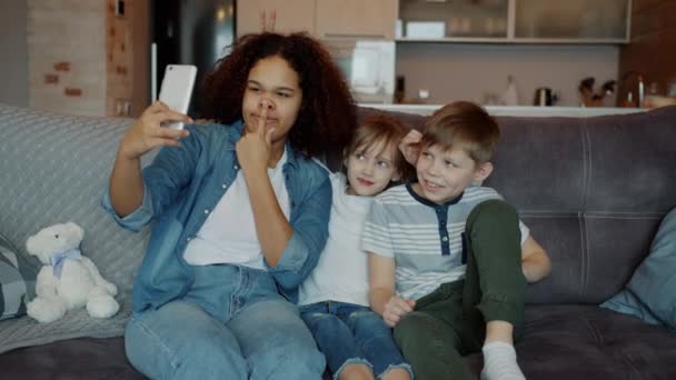 Långsamma rörelser av glada människor barnvakt och barn som tar selfie med smartphone kamera har kul — Stockvideo