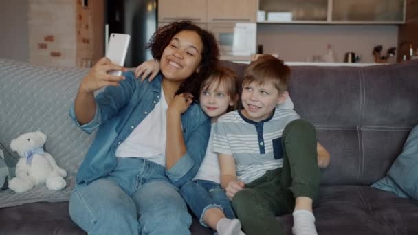 Αγαπώντας babysitter λήψη selfie με χαριτωμένα παιδιά αγκαλιάζει ποζάρουν για κάμερα smartphone — Αρχείο Βίντεο