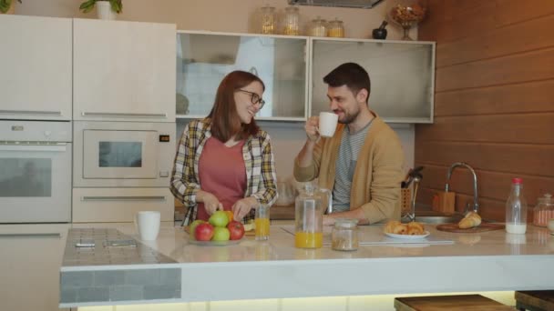 Gravid mor och far pratar i köket när son och dotter kommer och pratar äter — Stockvideo