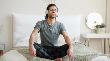 Pijamalı melez bir adamın portresi. Evde Lotus pozisyonunda meditasyon yapıyor.