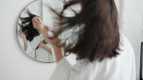 Movimento lento da menina bonita secando o cabelo com secador de cabelo e dançando no banheiro — Vídeo de Stock