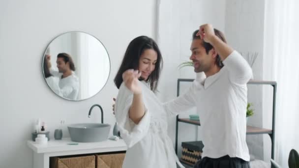 快乐人慢动作的女朋友和男朋友在浴室里跳舞微笑着 — 图库视频影像