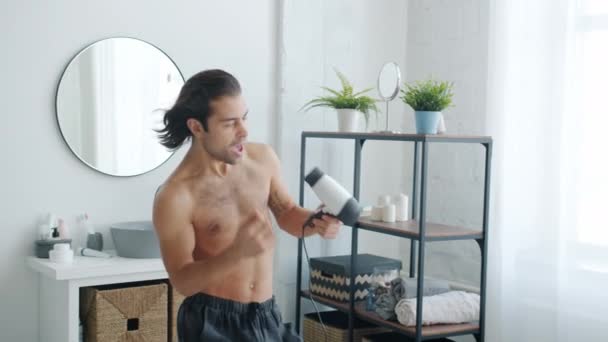 Lassú mozgás boldog srác tánc és éneklés szárító haj hajszárító a fürdőszobában otthon — Stock videók