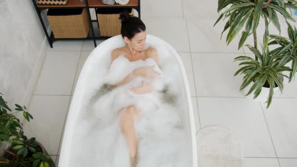 Slow motion of happy young woman bathing in modern bathtub smiling relaxing alone — Stock Video