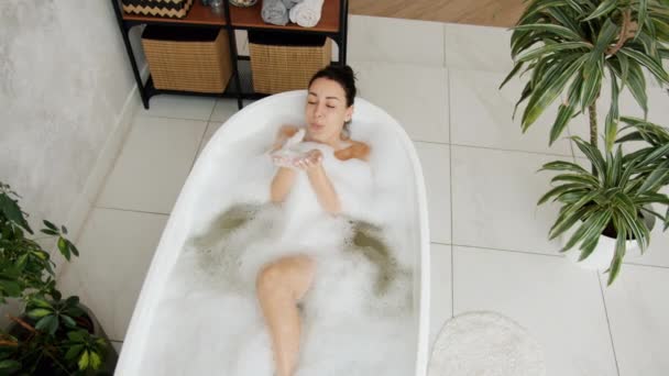 Movimento lento de menina despreocupada brincando com espuma na banheira relaxante se divertindo — Vídeo de Stock